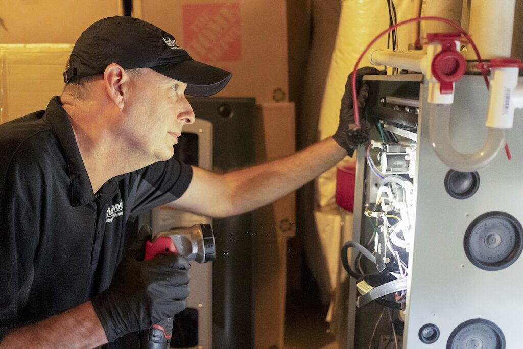 man inspecting an old furnace