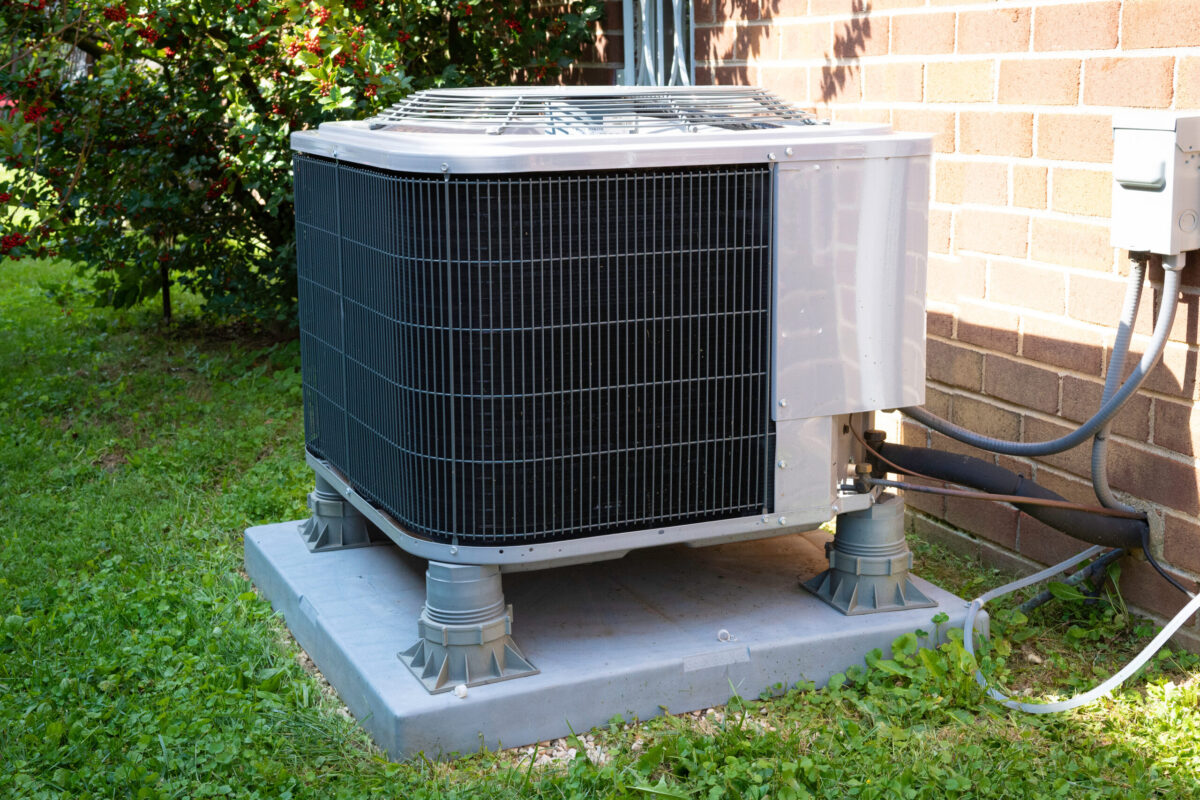 HVAC Air Conditioning Unit on concrete slab with new construction brick house