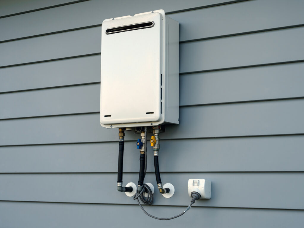 Modern external continuous flow gas water heater mounted on house wall how does a tankless water heater work