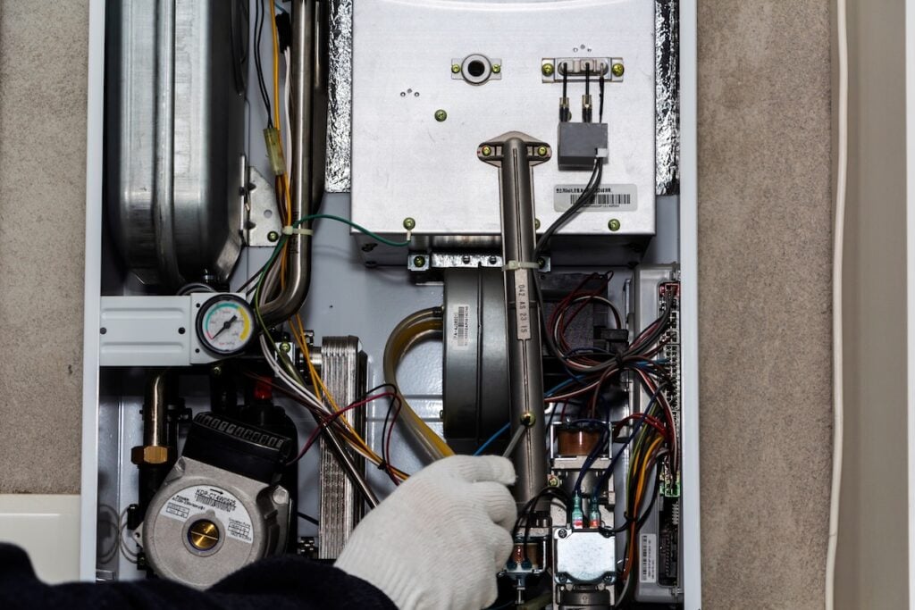how to save money on heating bill eating Central Gas Furnace Issue. Technician Trying To Fix the Problem with the Residential Heating Equipment.