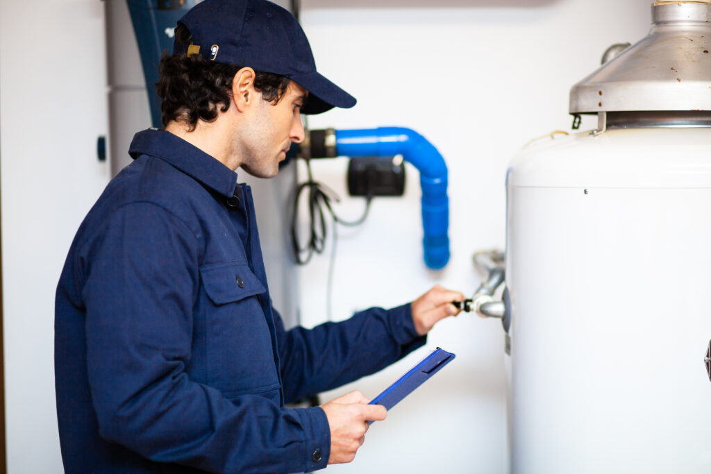 Smiling technician repairing an hot-water heater