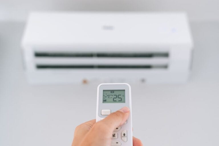 cooling installation woman hand setting ac temperature to 25°C