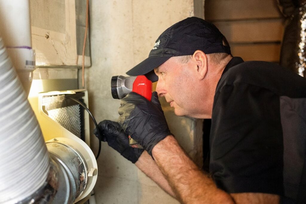 hvac repair cost Smock HVAC worker inspecting heater