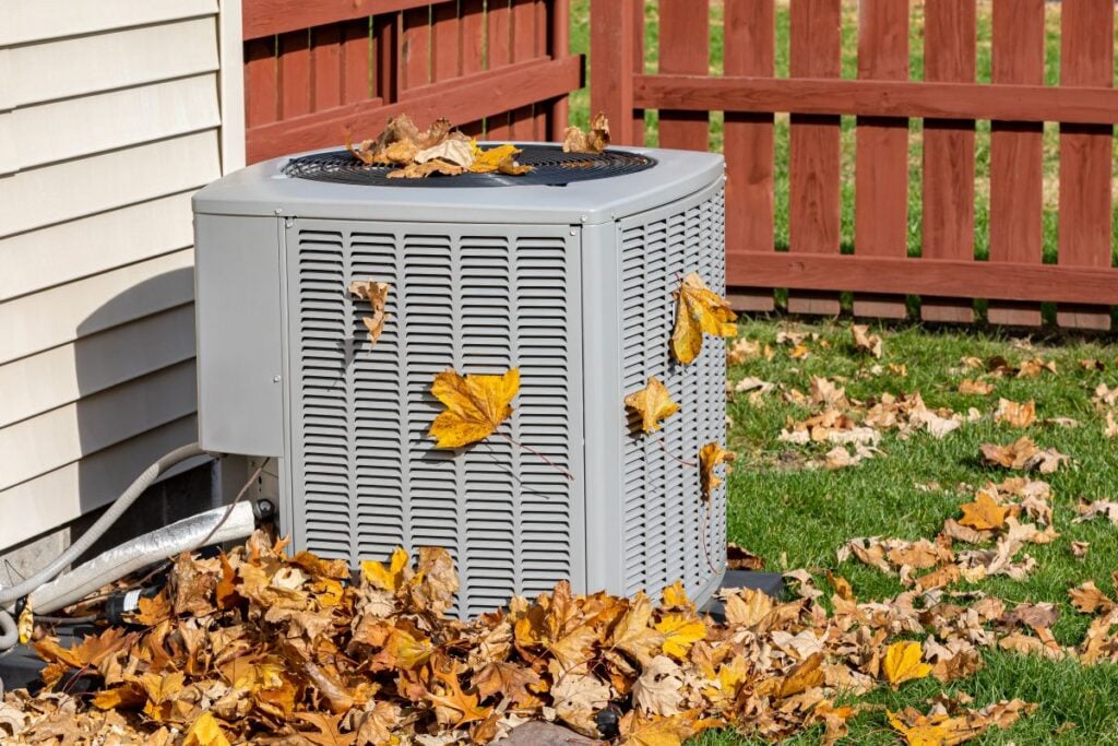 hvac repair cost air conditioner unit surrounded by leaves dirty