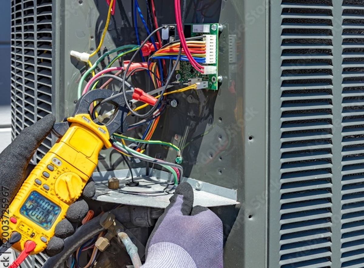 Technician man performing maintenance service on home air conditioning system, Worker hands using allen key to adjust valve on outdoor unit, HVAC contractor repairing a split system air conditioner
