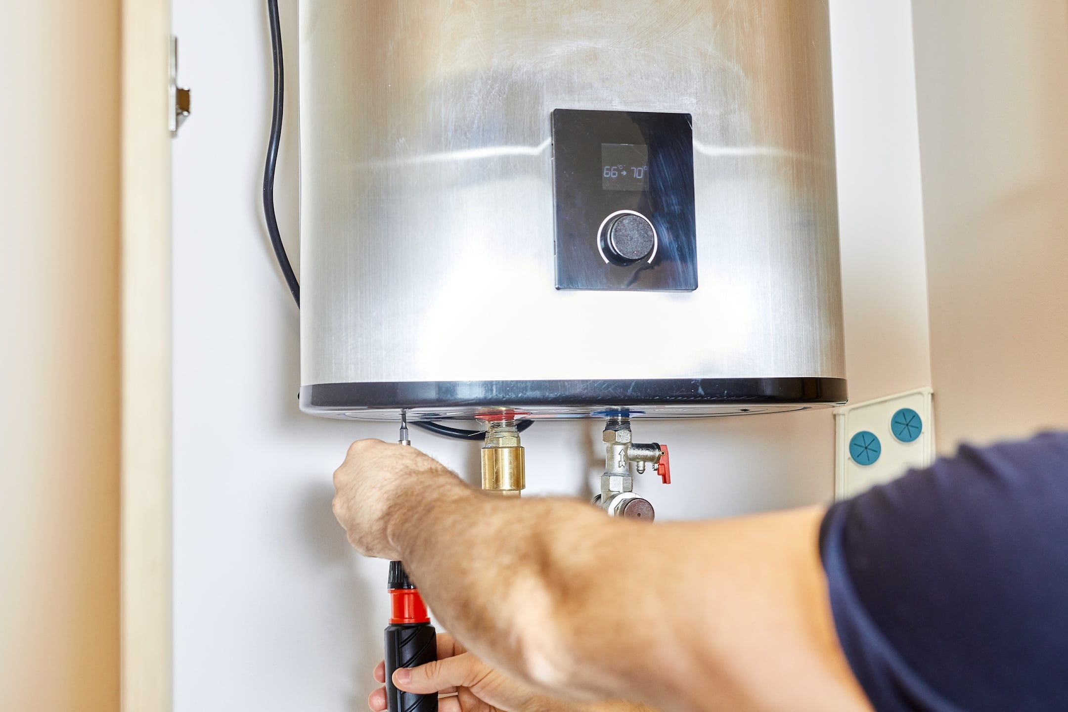 Man tightens the pipe nut in the water heating system.