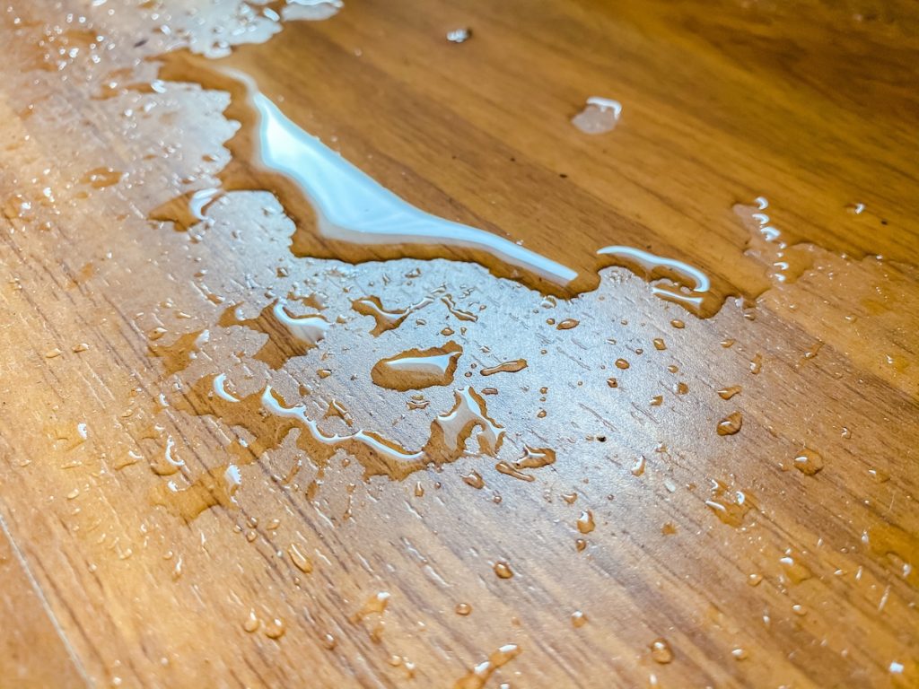 water spill on parquet wood floor, which leaking from air conditioner in the house.